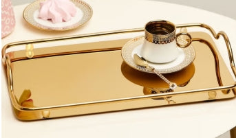صينية تقديم نوار إيديت باللون الذهبي تتميز بتصميمها المعدني اللامع الذي يجمع بين الأناقة والعملية، مما يجعلها مثالية لتقديم المشروبات والحلويات أو لعرض الديكورات والإكسسوارات المنزلية
